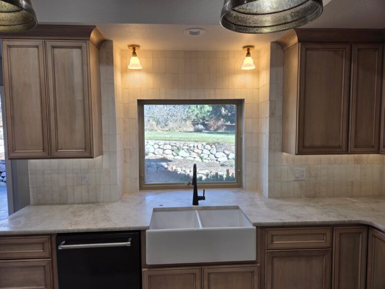 Kitchen renovation with new cabinetry, backsplash, and lighting
